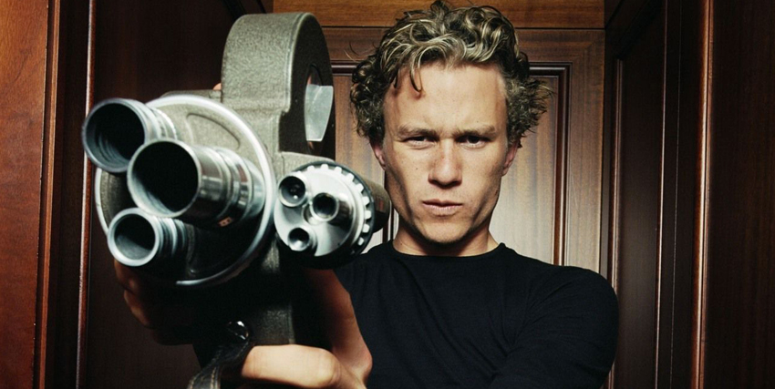 Primo piano di Heath Ledger con in mano una vecchia cinepresa - nerdface