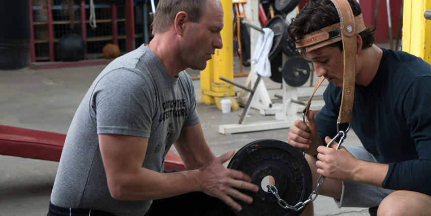 vinny paz si allena col suo coach sollevando col collo una pizza molto pesante - nerdface