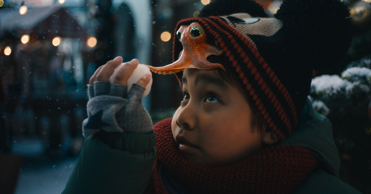 il bambino gioca con l'amico polpo e una palla di neve - nerdface